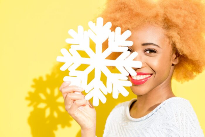 Portrait of a woman with artificial snowflake on the yellow background cosmetic dentist oxnard ca