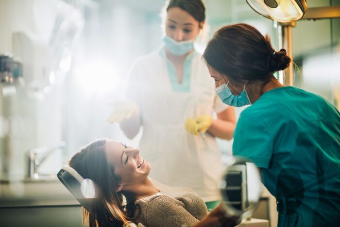 Smiling woman sitting in dental chair talking to dentist before procedure dental anxiety dentist in Oxnard California