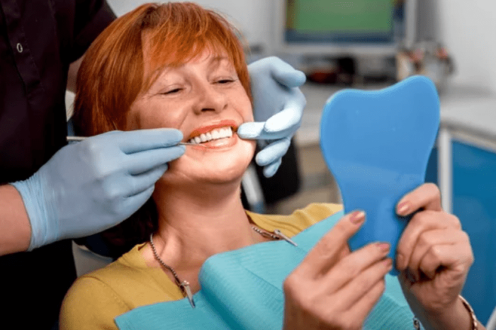 Woman in dental chair looking at her new smile with dentures restorative dentistry dentist in Oxnard California